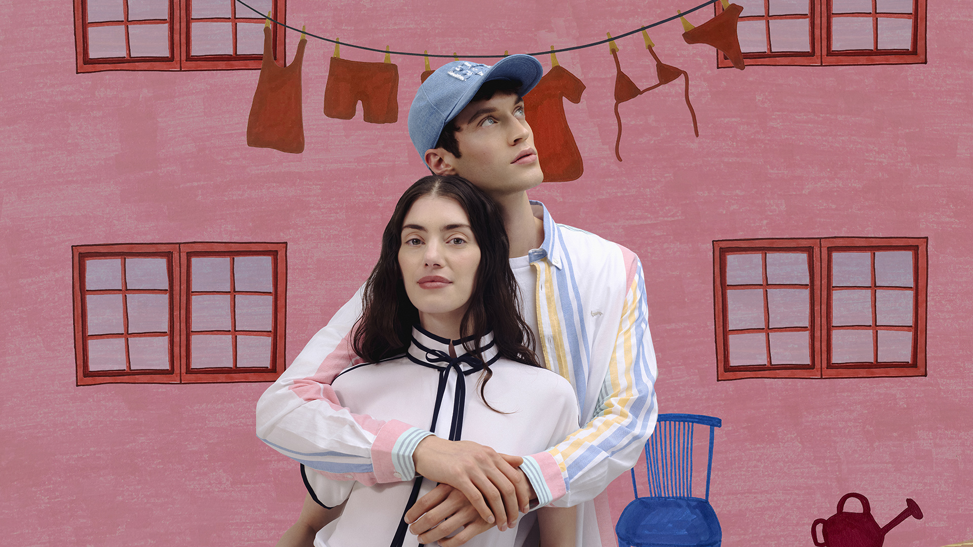 Uomo e donna con camicie a righe colorate e beachwear, davanti a un’illustrazione di piscina con palme — atmosfera vivace e audace dei saldi estivi.